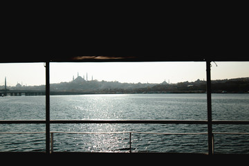 Shipyard, ferries and Istanbul Silhouette view during a foggy day from framed view by another ferry