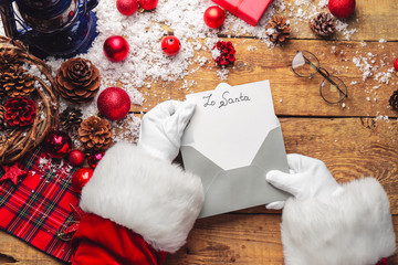 Fototapeta na wymiar Santa Claus opening letter on table