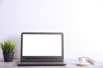 Modern white office desk table mockup ,work space with laptop computer with white screen for you text or  image,green grass,cup of coffee and a stack of papers on white rock background.