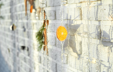 Christmas decor in the form of dried citrus orange slice on a white wall background.