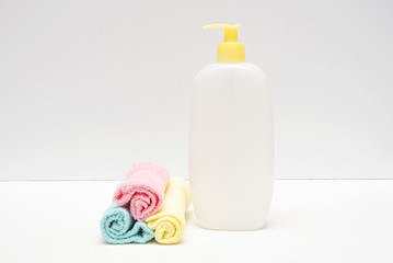 Detergent bottle and towels on white background.