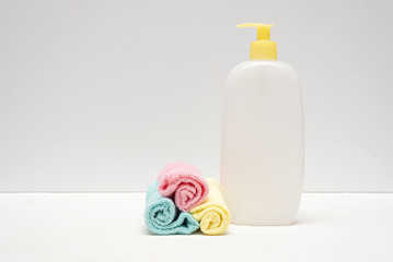 Detergent bottle and towels on white background.