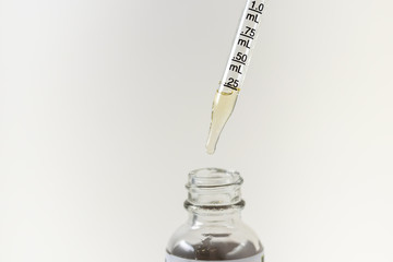 CBD being measured in a clear glass eye dropper for to administer cbd tincture to medical marijuana...