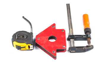 Fototapeta premium Carpentry clamp and measuring meter isolated on white background.Metal magnet