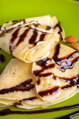 crepes with banana and chocolate spread on a green plate