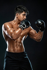Fitness and boxing concept. Boxer, man fighting or posing in gloves on black background. Individual...