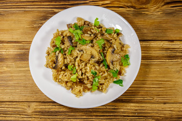 Tasty risotto with mushrooms on wooden table. Top view