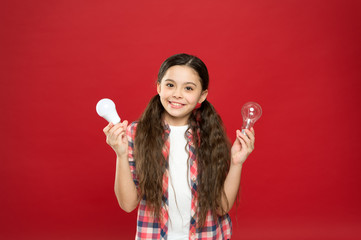 Eco life. Lighting choice. Little girl light bulbs on red background. Symbol of idea progress and innovation. Environment friendly lighting. Energy efficient lighting. Ecology problem. Climate change