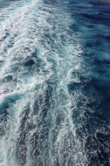 Cruise ship wake on a beautiful sunny day with white clouds and blue seas on the Atlantic Ocean.