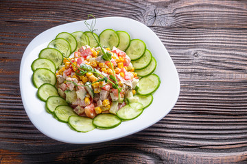 Fresh salad of vegetables and meat on wooden rustic background