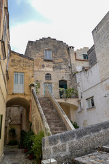 Fototapeta na wymiar antica strada in pietra con scala archi e finestre