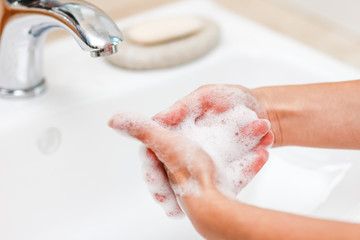 Fototapeta premium Hygiene concept. Washing hands with soap under the faucet with water