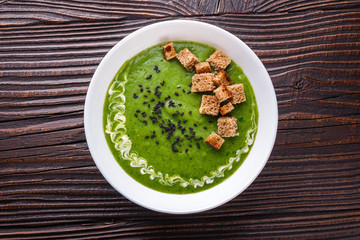 broccoli spinach cream soup on rustic wooden background