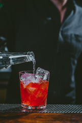 Bartender preparing cucumber martini cocktail at the bar, alcoholic drink