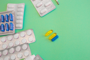 Tablets Vitamin pills and antibiotics on a colored background. Treating seasonal allergies, flu,...