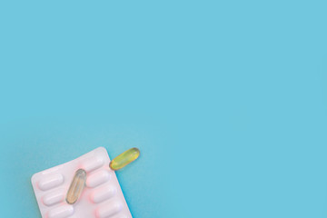Vitamin pills and antibiotics on a colored background. Treating seasonal allergies, flu, and illness