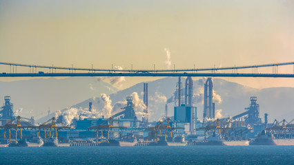 Sunrise autumn view to cargo carrier ships berthed near a Posco steel mill at the Port of Gwangyang, Jeonnam, Korea.
