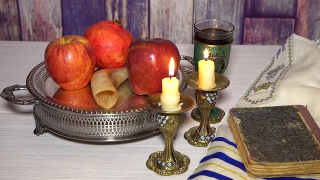 Jewish Holiday Rosh hashanah jewish New Year holiday concept. Traditional symbols Selective soft focus brass candlestick beside red apple fruit