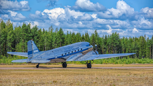 Short-haul transport aircraft with two piston engines Douglas DC-3A-447 OH-LCH Airveteran in Finnish Airlines livery landing on Karhula aviation museum airshow. Kotka, Finland.