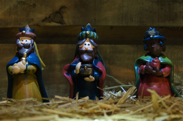 Christmas nativity scene of baby Jesus in the manger. Statuettes colored figures. Three wise men...