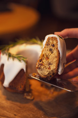 decorated Christmas cake - Traditional European Christmas pastry, fragrant home baked stollen, Sliced on wooden table with xmas tree branches and decorations