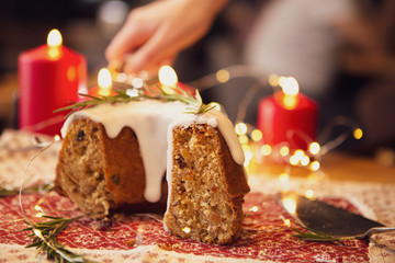 decorated Christmas cake - Traditional European Christmas pastry, fragrant home baked stollen, Sliced on wooden table with xmas tree branches and decorations