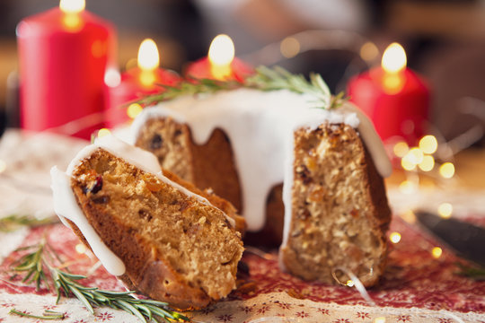 decorated Christmas cake - Traditional European Christmas pastry, fragrant home baked stollen, Sliced on wooden table with xmas tree branches and decorations
