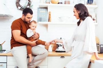 young family with little cute son on kitchen in morning happy smiling, lifestyle people concept