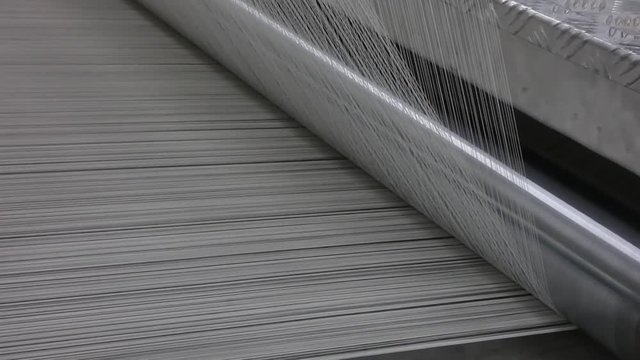 macro shooting of cotton thread twisting on the shaft. machinery and equipment in a textile factory