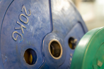 A blue and a green metal barbell 20 kilogram plate (shallow depth of field)