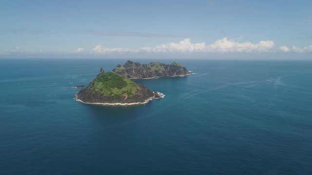 Small rocky islands in sea, blue sky and clouds. Dos Hermanas, Palau, Santa Ana. Aerial view of seascape with tropical islands in the ocean.