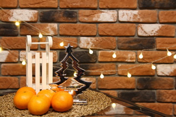 Christmas decoration - silver christmas tree candle holder and white wooden sledge on the brick wall