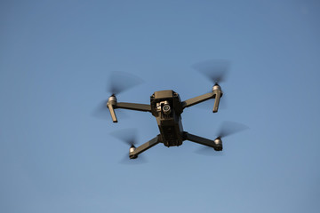 Flying quadrocopter drone in the sky. Aerial photography.