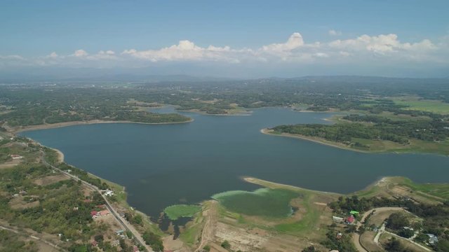 Aerial view Paoay Lake with water lilies, Philippines. Lake against background of mountains and sky with clouds. Paoay Lake National Park, Ilocos Norte.