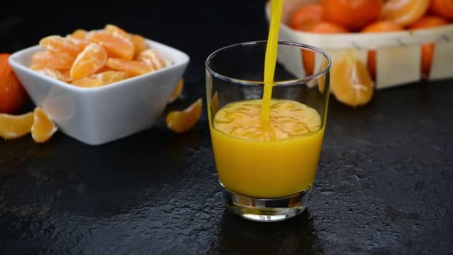 Pour tangerine juice in a glass (4K)