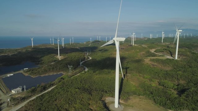 Aerial view Windmills for electric power production on the seashore. Bangui Windmills in Ilocos Norte, Philippines. Solar farm, Solar power station. Ecological landscape: Windmills, sea, mountains.Pag