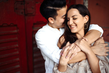 Charismatic guy and beautiful girl hug each other with love, outdoors