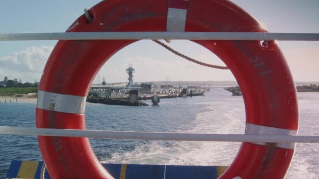 Looking through buoy as boat leaves port