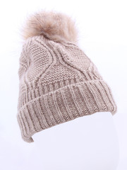Knitted beautiful light brown wool hat with fur ball pompom, close knit, isolated on white background