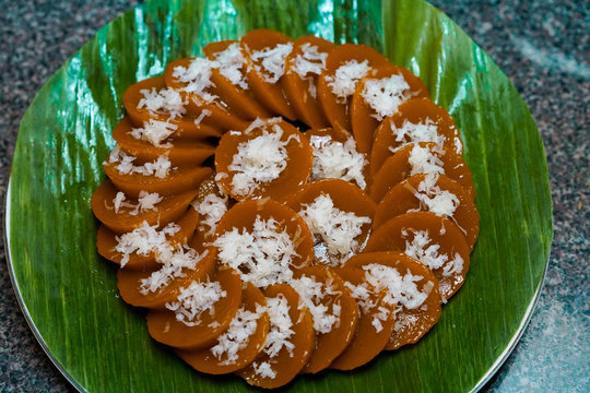 Closeup view of homemade Filipino dish Kutsinta with coconut flakes served on banana leaf