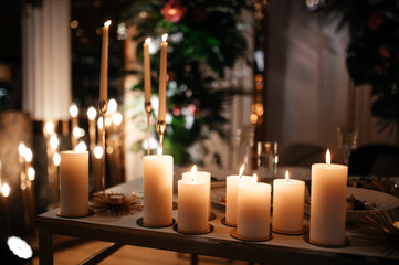 Burning candles. Beautiful composition of many burning candles on the table. Atmosphere.