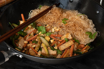 Vegan vegetables and tofu stir fry with bean thread noodles served in wok