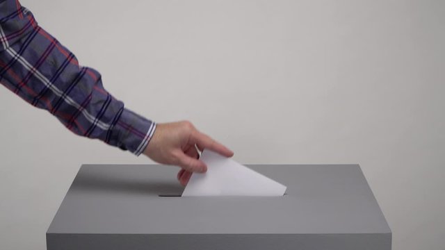 Gray ballot box. Presidential and parliamentary elections. The voter throws the ballot into the ballot box.