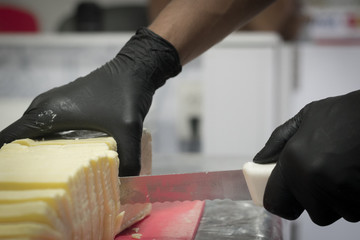 photograph cutting cheese with long knife and vignette