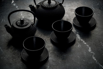 teapots and wells on black stone background