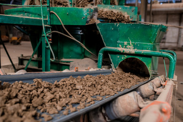 Obraz premium Plant for the production of bricks from clay. Plant for production building material with ready brick, construction industrial. Production of bricks on plant. Workflow, close-up. Many bricks