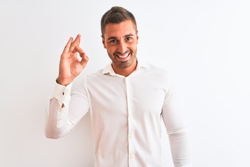Fototapeta premium Young handsome business man wearing elegant shirt over isolated background smiling positive doing ok sign with hand and fingers. Successful expression.