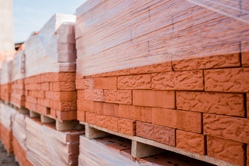 Plant for the production of bricks from clay. Plant for production building material with ready brick, construction industrial. Production of bricks on plant. Workflow, close-up. Many bricks