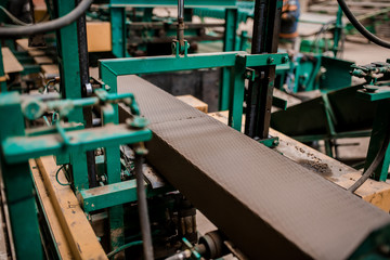 Plant for the production of bricks from clay. Plant for production building material with ready brick, construction industrial. Production of bricks on plant. Workflow, close-up. Many raw bricks