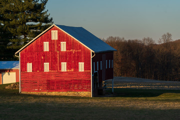 Obraz premium Red Barns and Farm Fields in a Winter Sunset